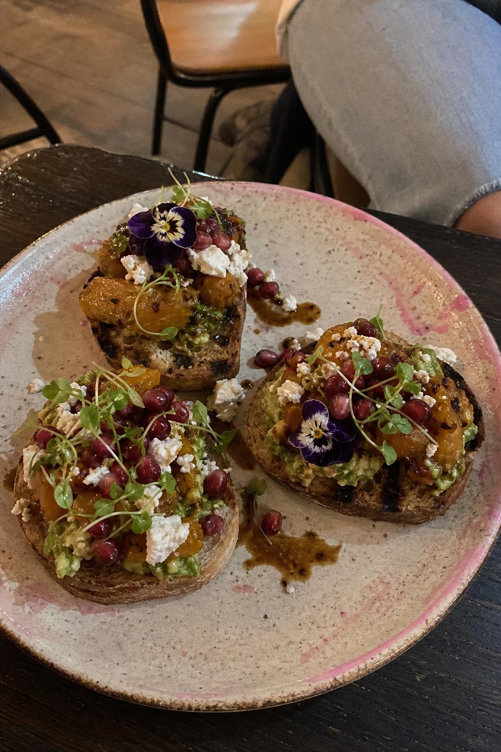 Pumpkin and pomegranate bruschetta with edible flowers